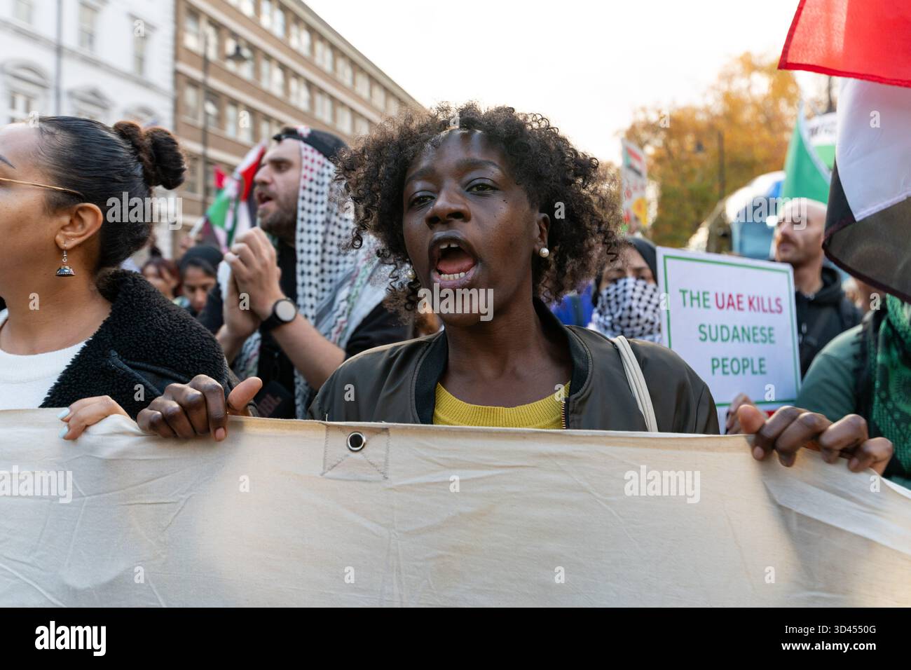 London, Großbritannien. November 2025. Eine Frau singt Slogans, während sie während der Kundgebung ein Banner hält. Demonstranten marschierten in London, um Solidarität mit dem sudanesischen Volk zu zeigen und für ein Ende der britischen Waffenverkäufe an die VAE zu plädieren, die laut Aktivisten Gräueltaten der RSF-Miliz im ganzen Land ermöglichen. Quelle: SOPA Images Limited/Alamy Live News Stockfoto