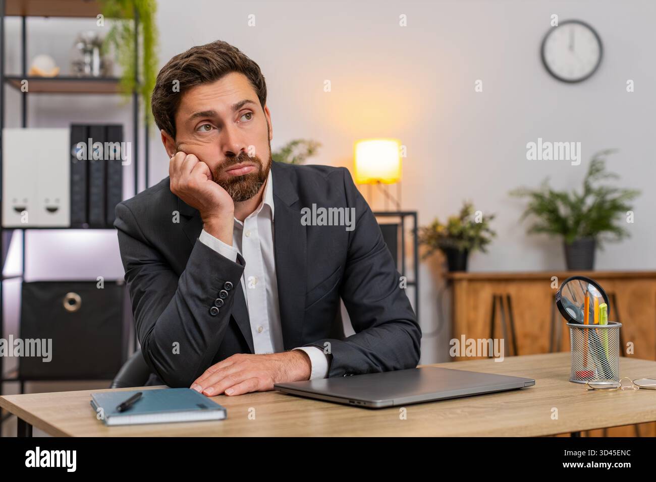 Ein Geschäftsmann mittleren Alters im Home Office schließt den Laptop schnell und ärgert sich über langweilige Aufgaben. Freelancer Guy am Tisch reibt Augen dehnt sich macht kurze Pause und kehrt dann wieder zur Arbeit zurück. Stockfoto