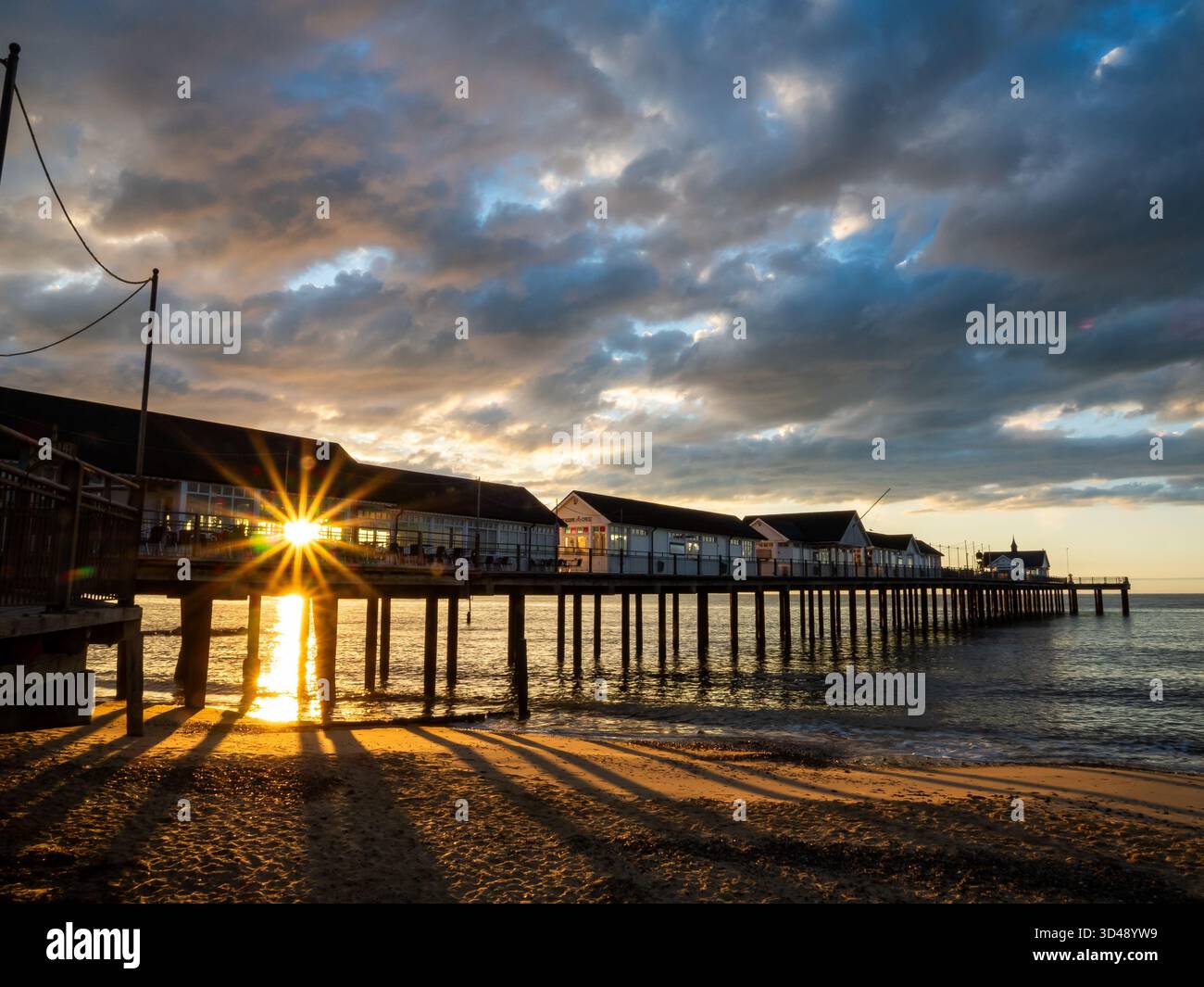 Am frühen Morgen scheint Sonnenlicht durch die Stützen des Southwold Pier Stockfoto
