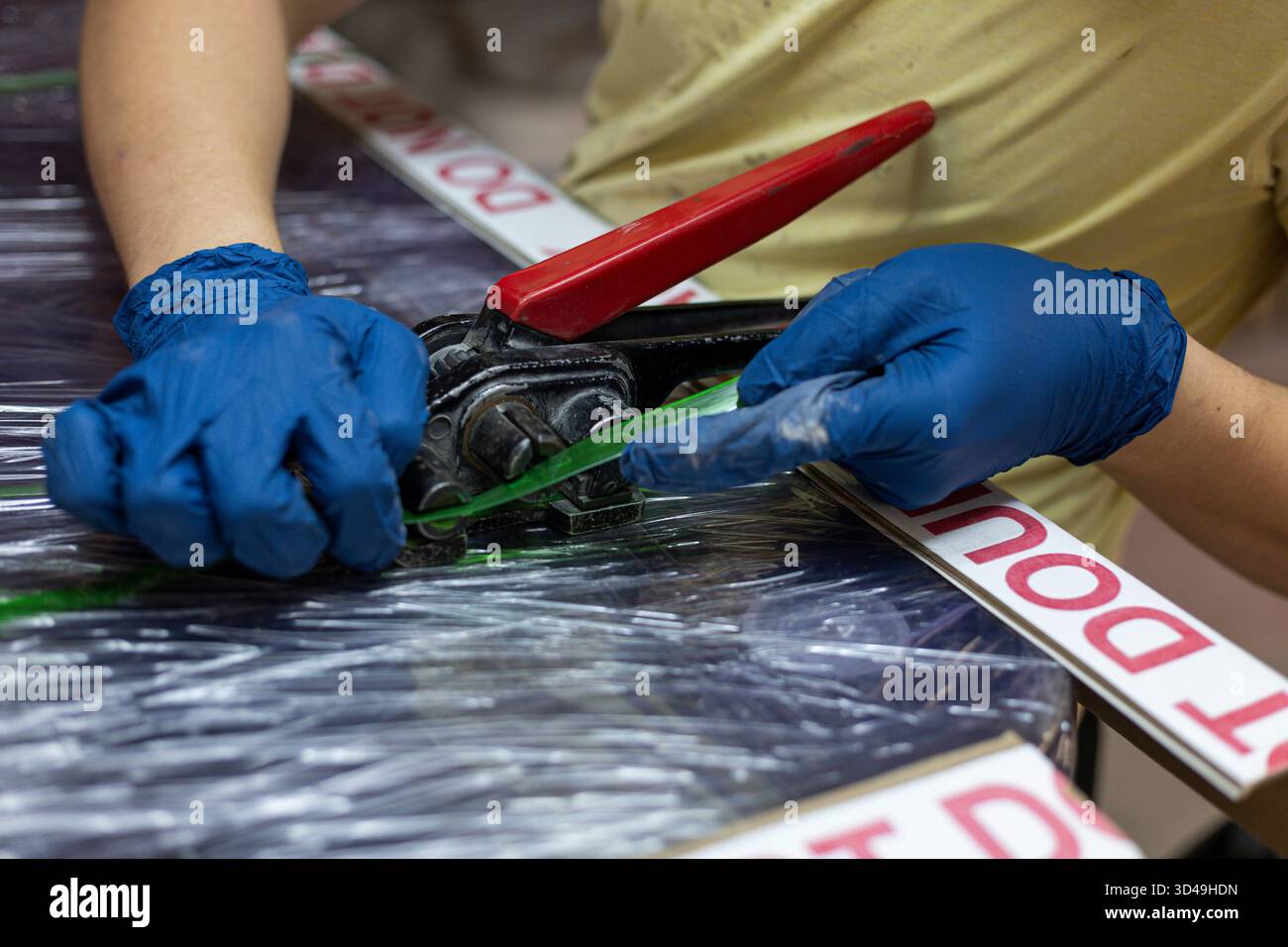 Die Hände des Mannes mit Werkzeugen und Zubehör für Polyethylenbänder. Lager Stockfoto