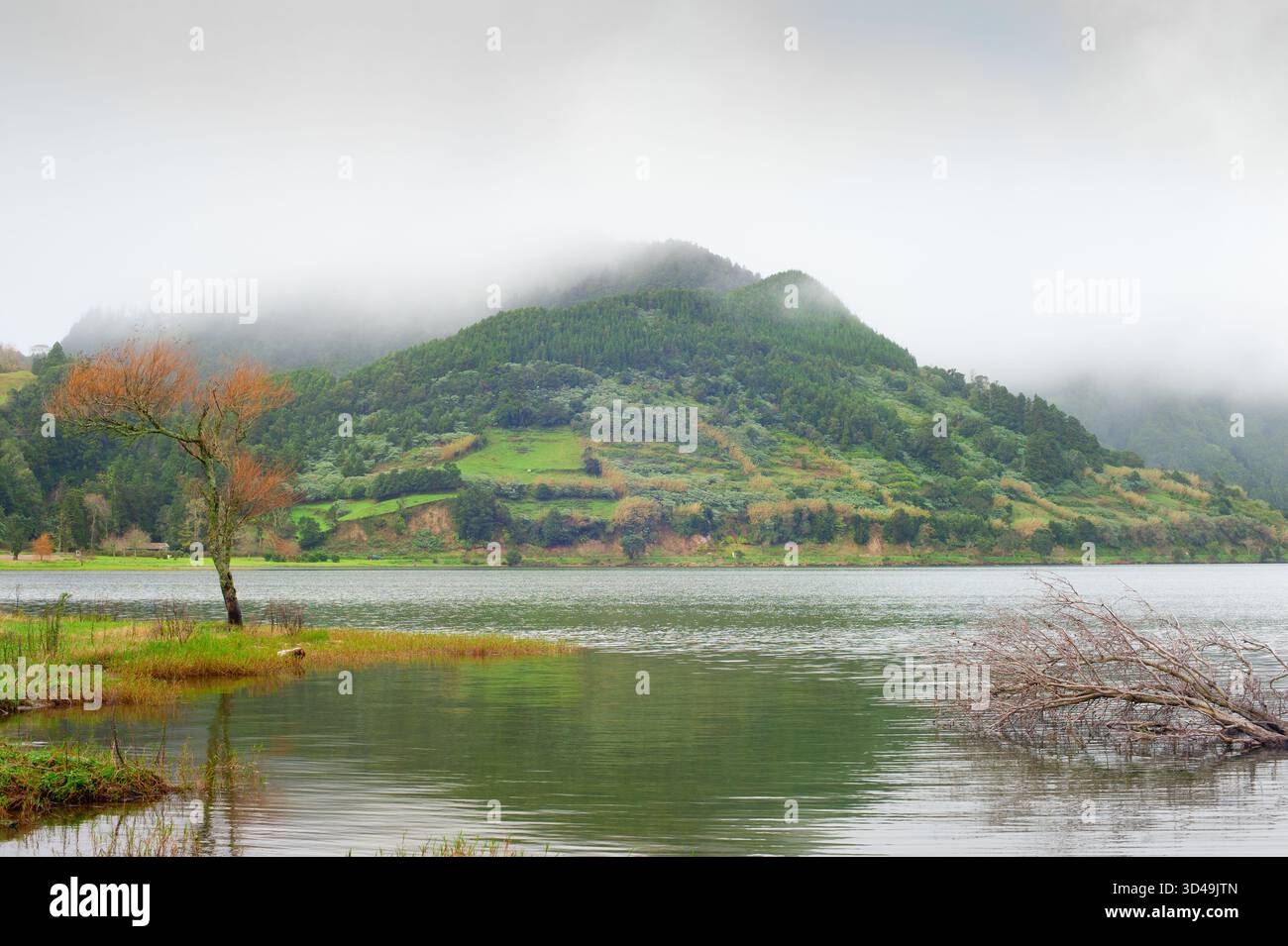 Landschaft mit einem See und Bergen an einem nebeligen Morgen. Insel Sao Miguel, Azoren, Portugal Stockfoto