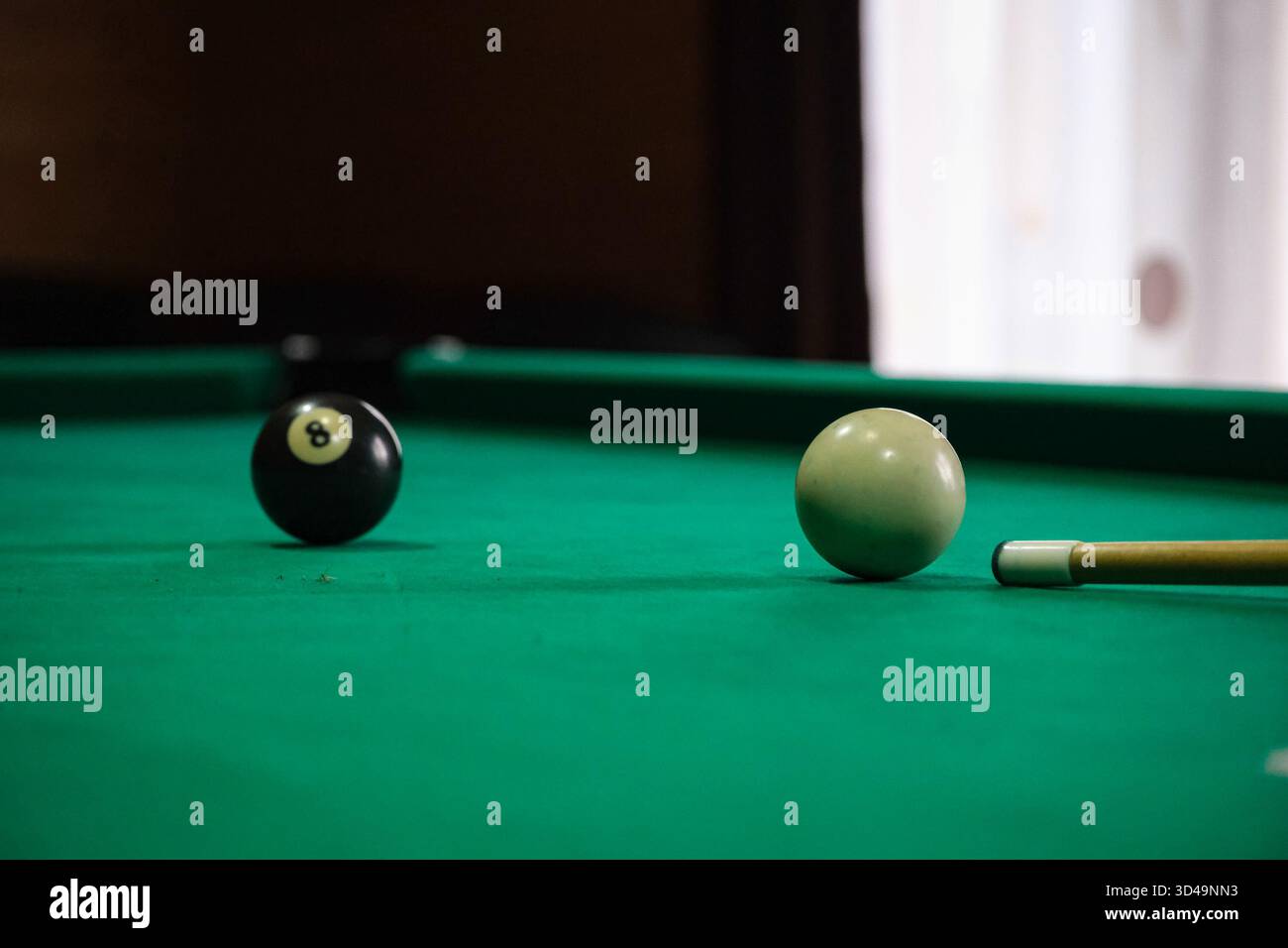 Billardtisch mit schwarzer Acht-Kugel und weißem Queuball bereit für einen Schuss Stockfoto