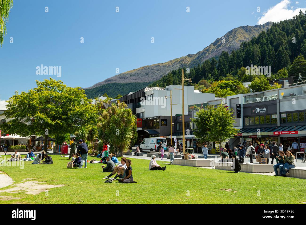 Menschen genießen die Sonne im Earnslaw Park Queenstown, Otago, Neuseeland Stockfoto