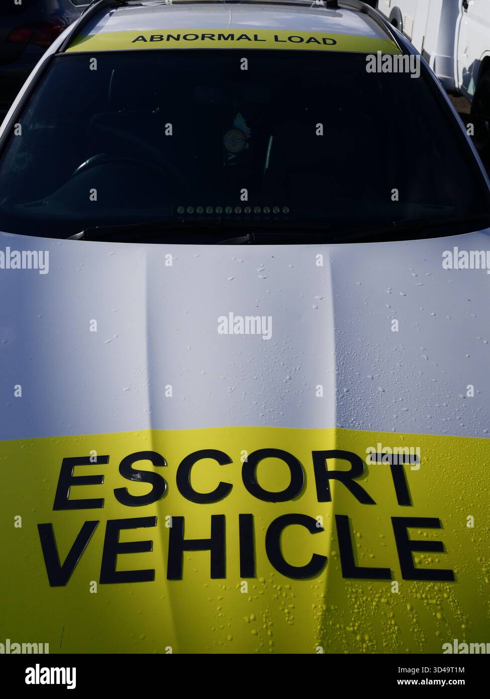 Mit Transportkennzeichnung gekennzeichnetes Begleitfahrzeug, das eine große oder übergroße anormale Ladung begleitet, um die Straßensicherheit zu gewährleisten. UK Stockfoto