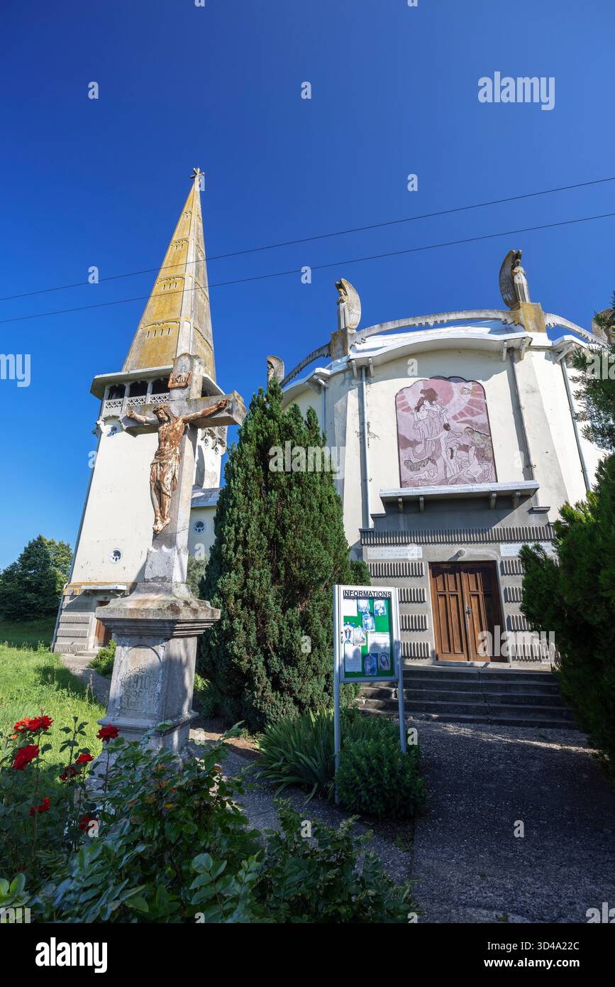 Modernistische Kirche des Heiligen Geistes und Kruzifix mit blauem Himmel in Mula, Slowakei Stockfoto