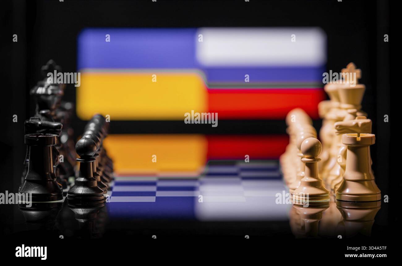 Konzeptuelles Bild des Krieges zwischen Russland und der Ukraine mit Schachfiguren und Nationalflaggen auf einem reflektierenden Hintergrund Stockfoto