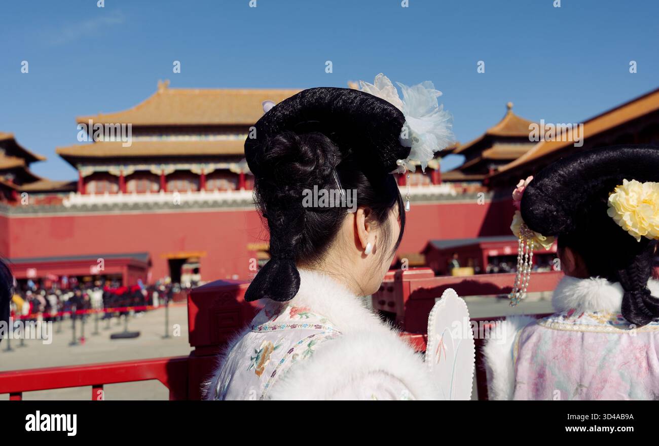 Zwei Frauen in traditioneller chinesischer Kleidung und raffinierten Frisuren stehen vor der Verbotenen Stadt Stockfoto