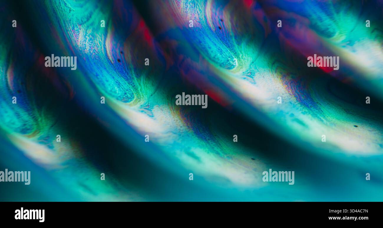Defokussiertes Tropfenöl. Farbmischung. Grüne orange blaue Tinte Wasserstruktur runde Strömungsblasen gießen auf abstraktem Acrylglas Neon Licht Kunst Hintergrund. Stockfoto