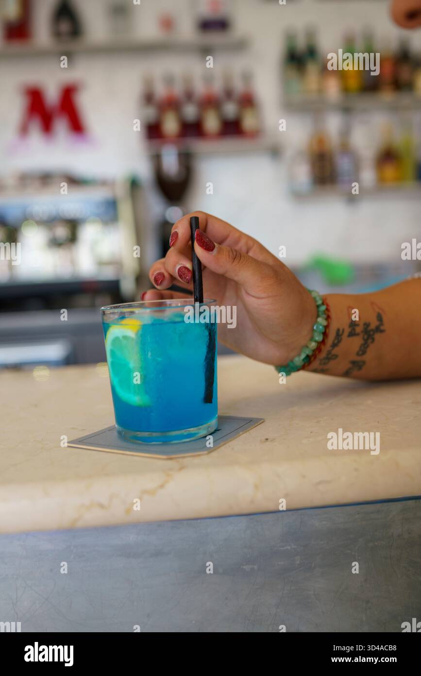 Crema, Italien - 25. August 2025 erfrischender Blauer Cocktail mit Zitronengarne, serviert an einer stilvollen Bar mit subtilem künstlerischem Flair Stockfoto