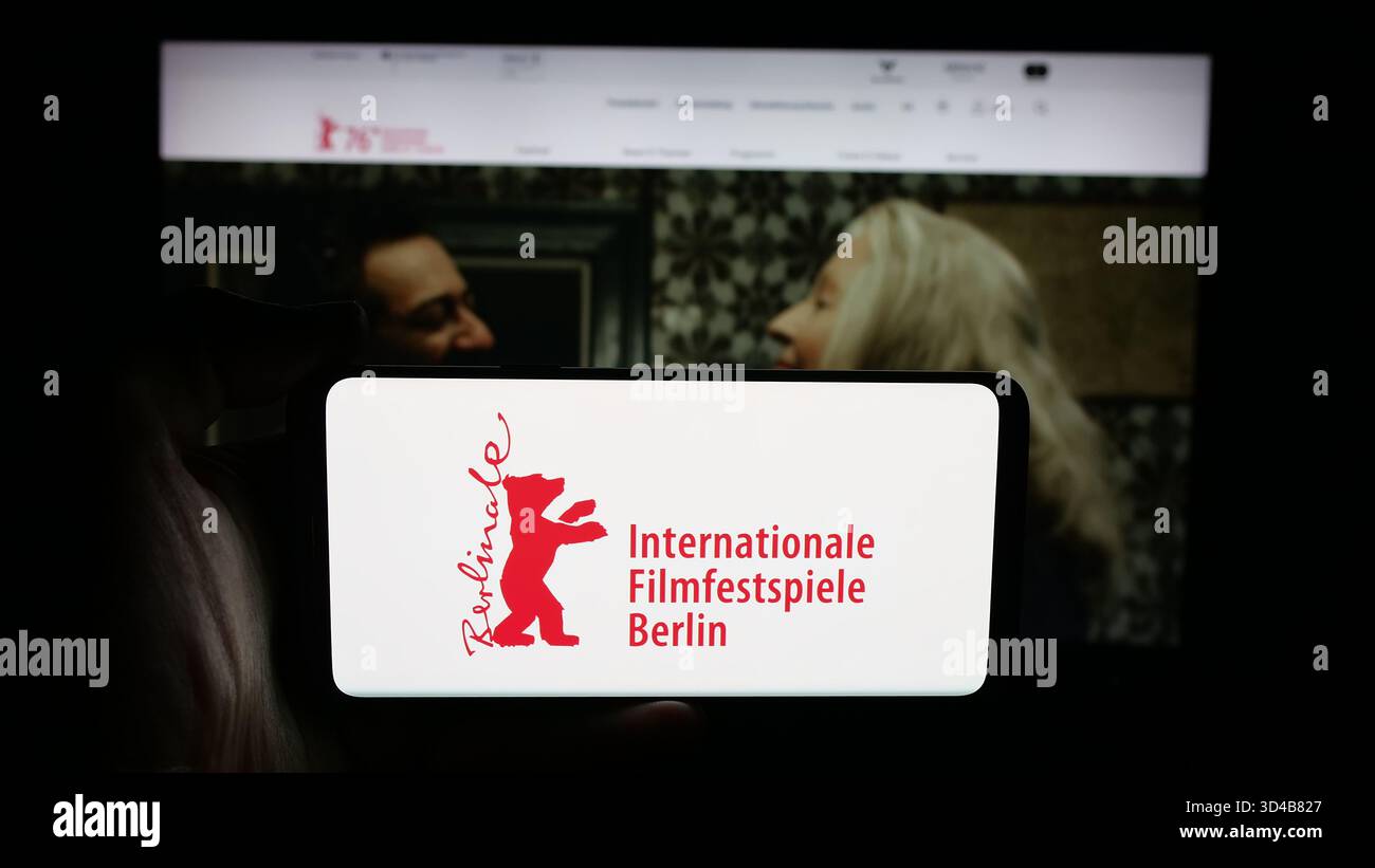 Stuttgart, Deutschland - 10-31-2025: Person mit Handy mit Logo der Internationalen Filmfestspiele Berlin Berlinale auf dem Bildschirm vor der Webseite. Stockfoto