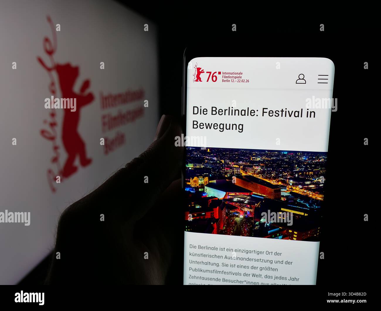 Stuttgart, Deutschland - 10-31-2025: Person mit Handy mit Webseite der Internationalen Filmfestspiele Berlin Berlinale auf dem Bildschirm vor dem Logo. Stockfoto