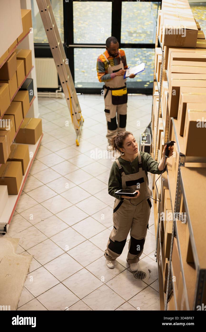 Mitarbeiter, die einen Handscanner verwenden, um Lagerbestandsdatensätze zu aktualisieren, Produkte für E-Business-Sendungen, Express-Paketzustellungen und die Verarbeitung von Einzelhandelsaufträgen zu verwalten. Qualitätskontrolle. Stockfoto