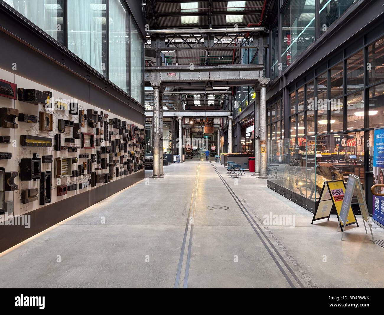 Eveleigh Lokomotivwerkstätten, Sydney. Umfunktionierte industrielle Innenausstattung mit freiliegenden Stahlträgern, Eisenbahngleisen, einer historischen Schaumauer und modern Stockfoto