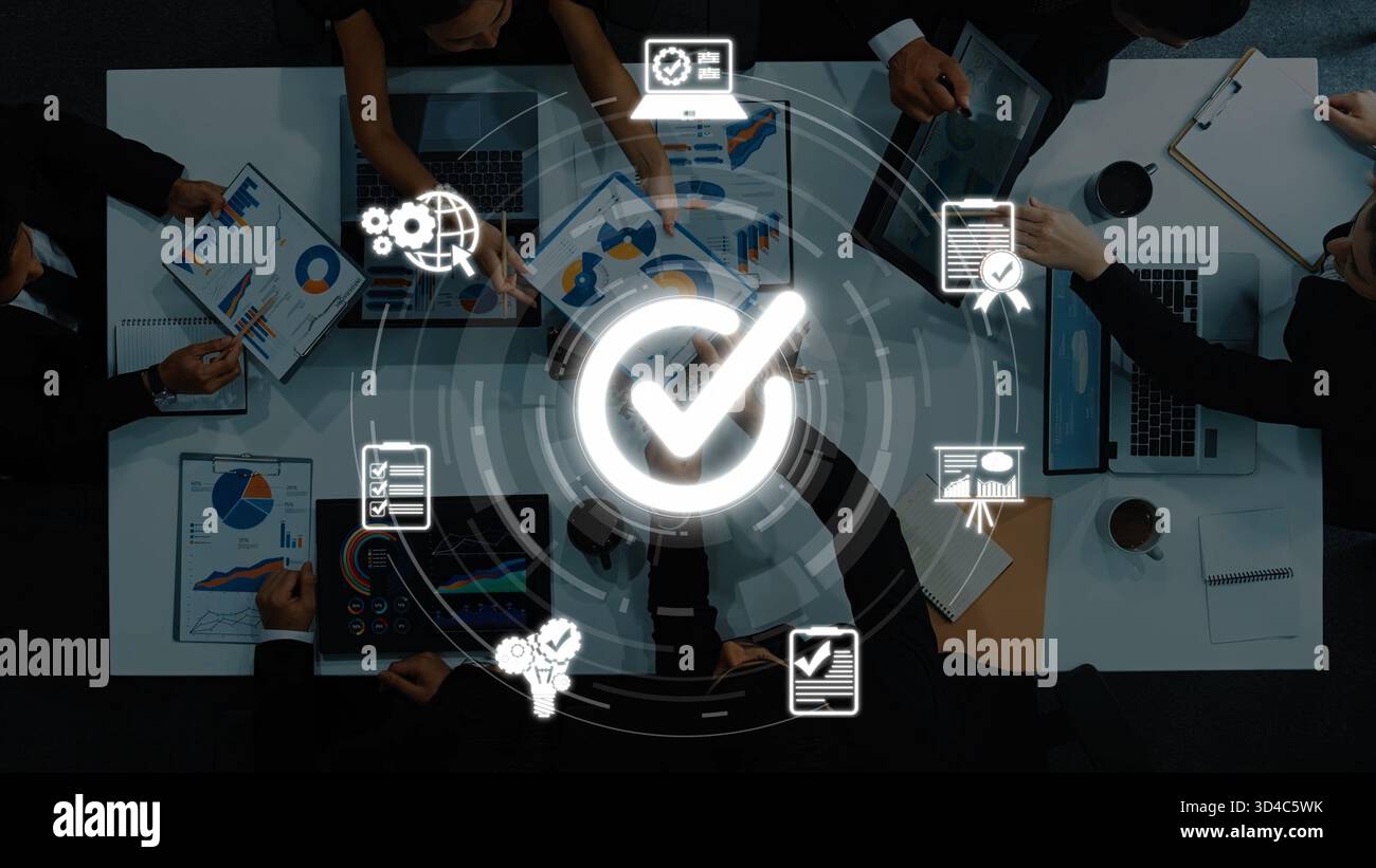 Ein Geschäftsteam arbeitet an der strategischen Planung rund um einen Tisch, zeigt Diagramme und Diagramme an, um die Zusammenarbeit und den Erfolg eines Profis hervorzuheben Stockfoto