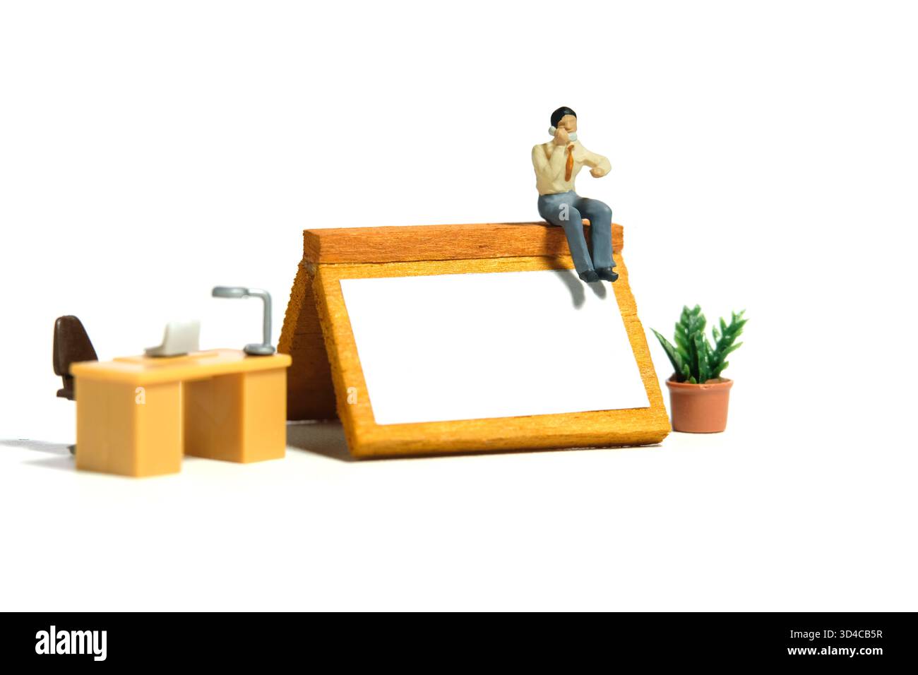 Miniatur-Kleinkinder-Spielfiguren-Fotografie. Konzept zur Erinnerung an den Zeitplan für Telefonanrufe. Ein Geschäftsmann telefoniert über dem Kalender des Schreibtischs. Stockfoto