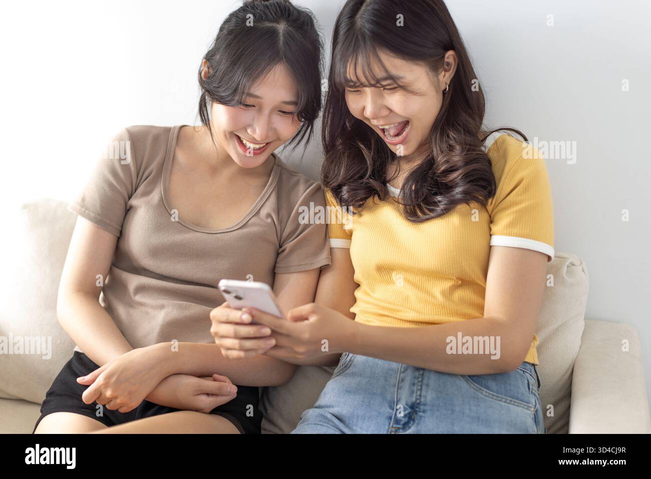 Glückliche junge Studentinnen, die das Smartphone sehen Stockfoto