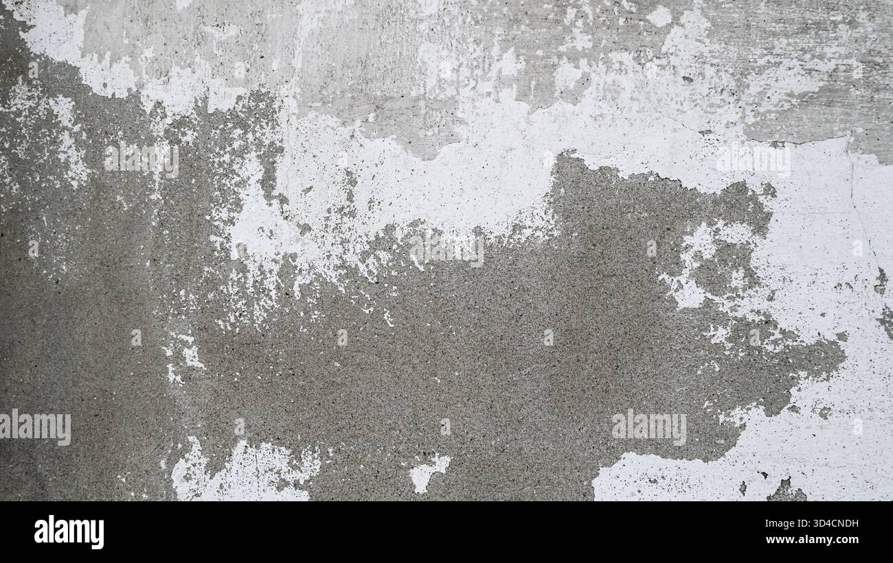 Alte Betonwand mit abblätternder weißer Farbe. Verwitterter rauer Untergrund mit Rissen und Flecken. Stockfoto