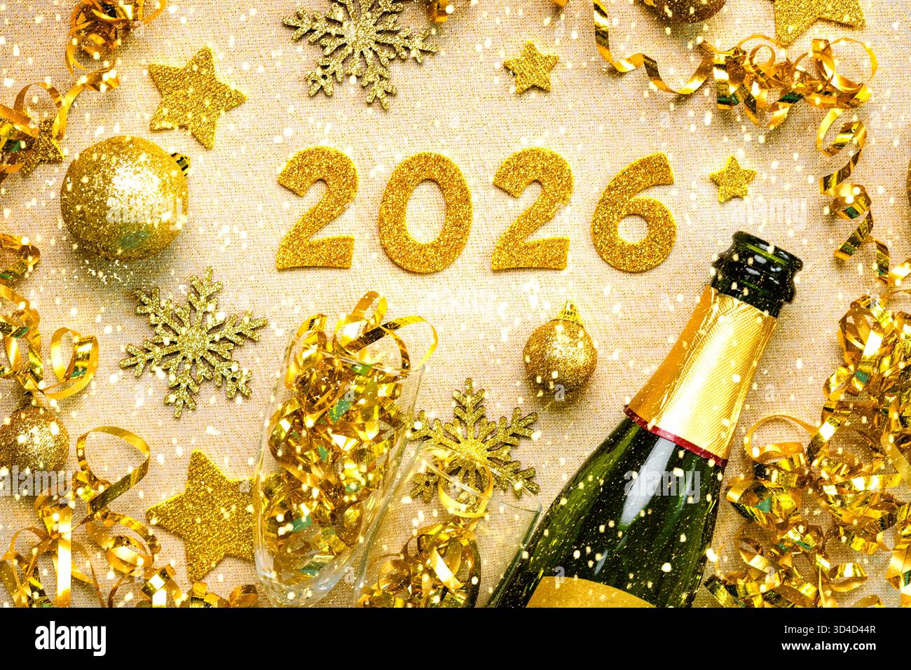 Flasche Champagner mit Kristallgläsern, goldenen weihnachtskugeln, goldenen Sternen und 2026 in goldenen Zahlen auf einer goldenen Tischdecke mit Glitzer. Silvester ce Stockfoto