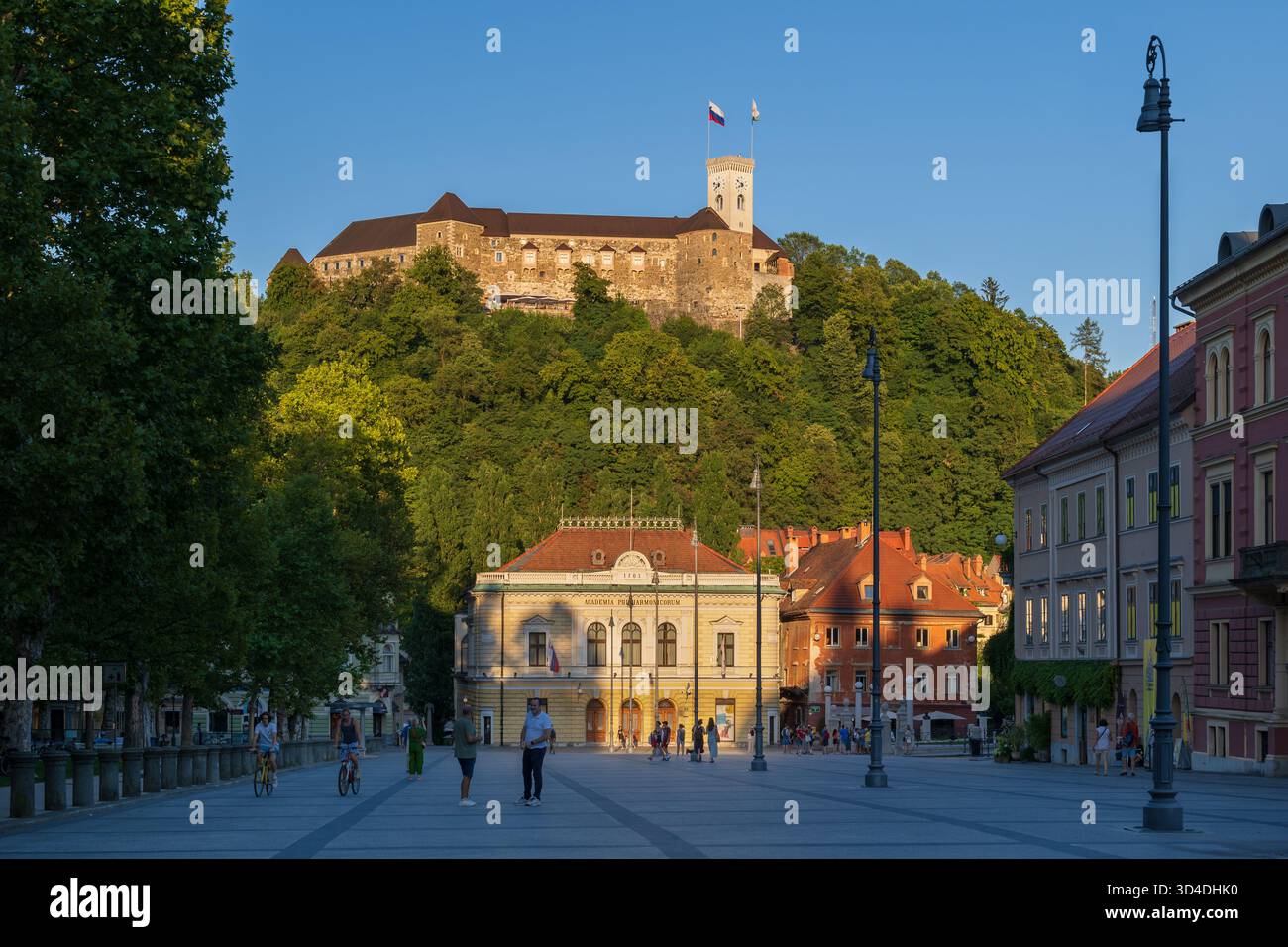 Ljubljana, Slowenien - 19. Juli 2022: Burg von Ljubljana auf einem Hügel und slowenisches Philharmonie-Gebäude bei Sonnenuntergang vom Kongressplatz, Wahrzeichen in der Geschichte Stockfoto