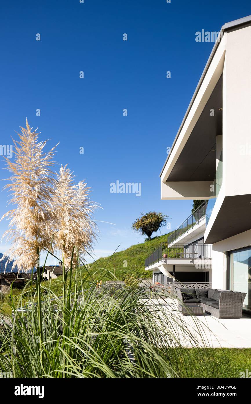 Detail eines modernen Hauses mit Terrasse und Wohnzimmer im Freien. Sonniger Tag mit blauem Himmel. Wunderschönes Hotel Stockfoto