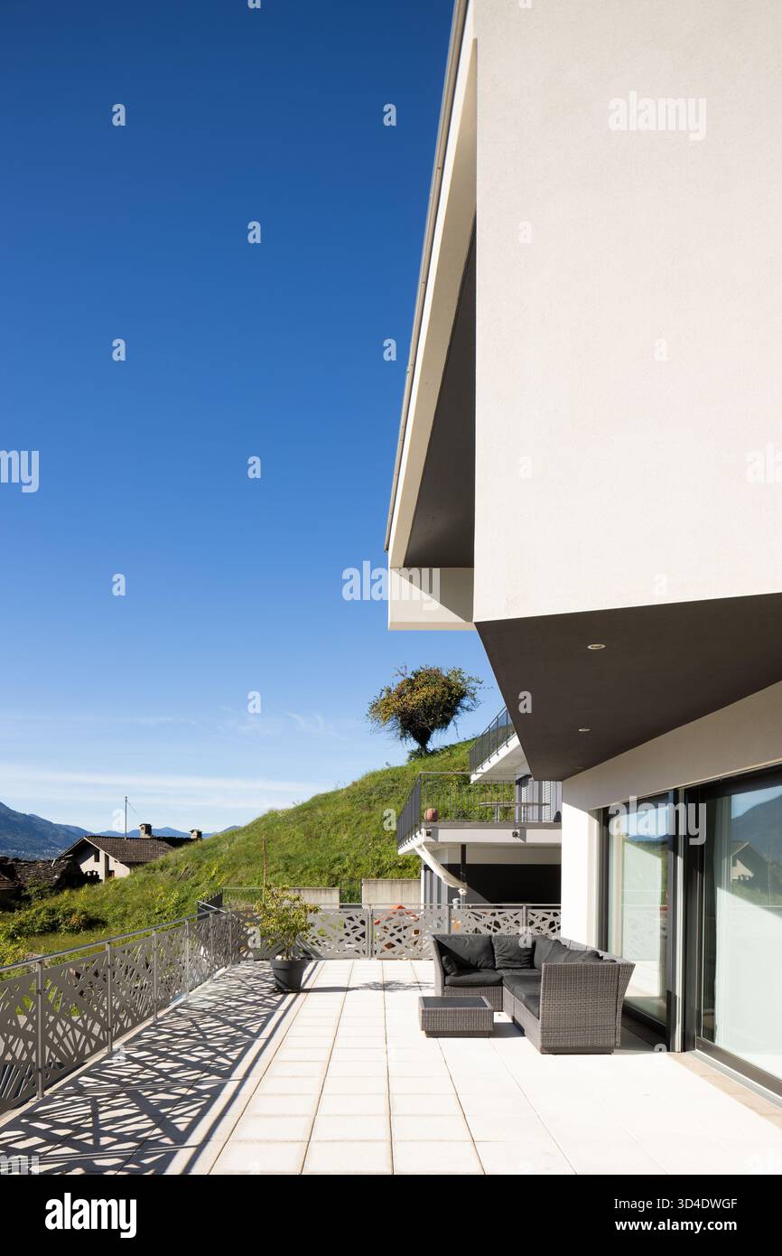 Detail eines modernen Hauses mit Terrasse und Wohnzimmer im Freien. Sonniger Tag mit blauem Himmel. Wunderschönes Hotel Stockfoto