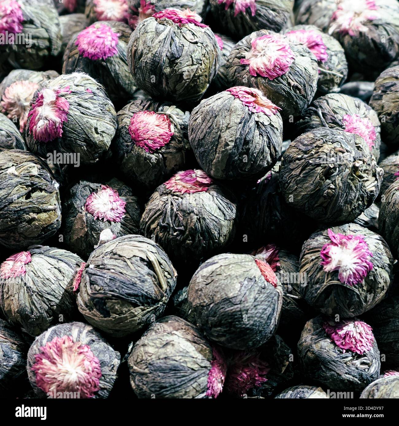 Istanbul, Türkiye - 8. November 2025: Nahaufnahme einer großen Ausstellung von handgebundenen blühenden Teebugeln, bestehend aus getrockneten Camellia sinensis Blättern und Gomphrena Stockfoto