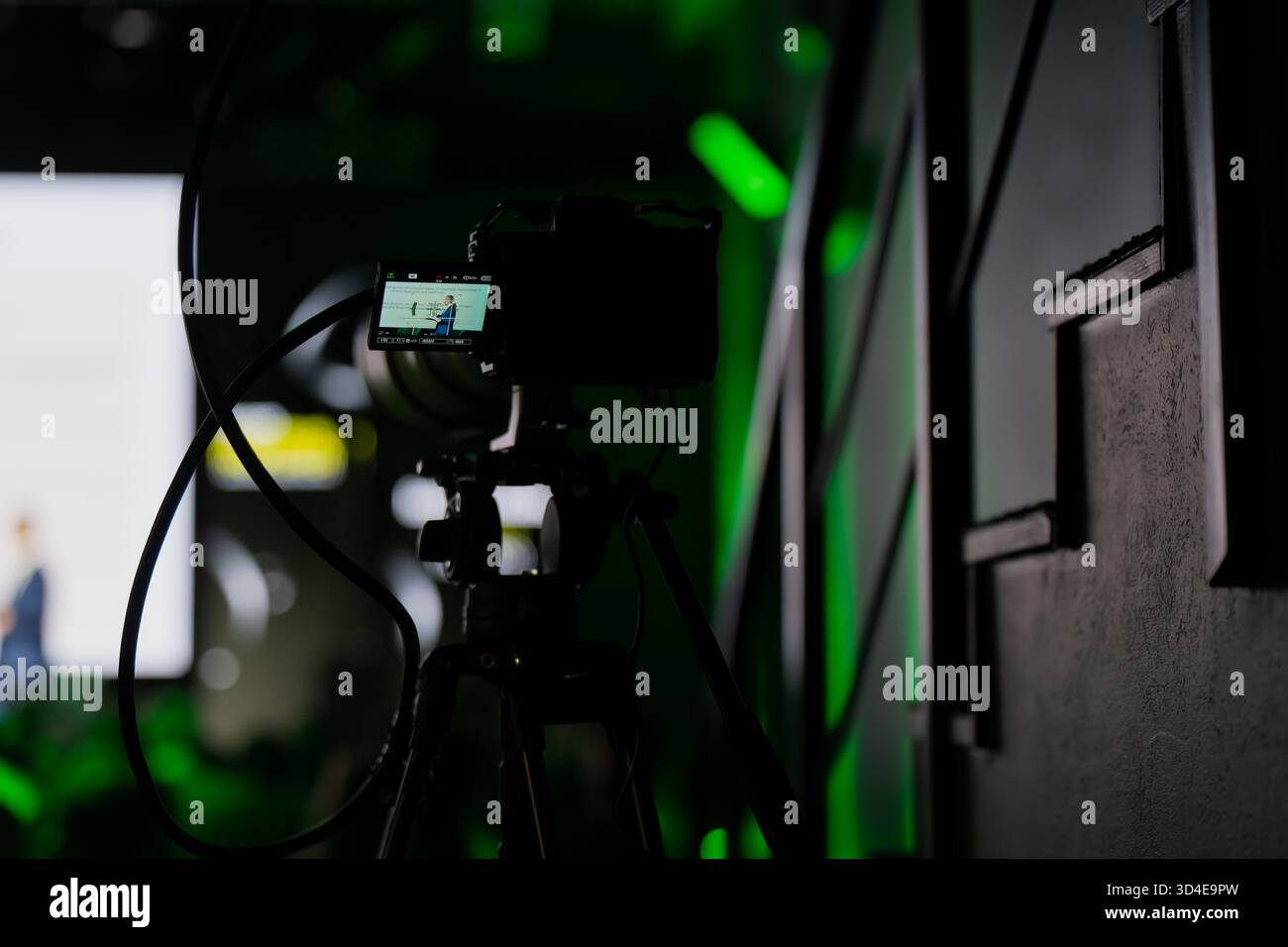 Digitale spiegellose Kamera auf Stativ, Filmpräsentation im Konferenzsaal mit professioneller Beleuchtung, symbolisiert Live-Streaming und Event-Vide Stockfoto