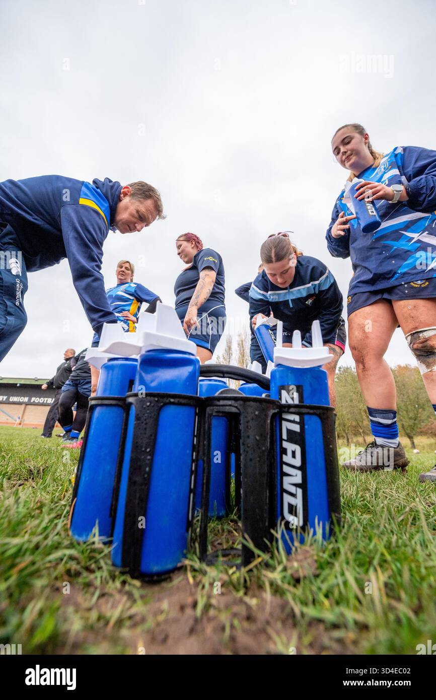 Weibliche Amateur-Rugby-Union mit blauen Ziland-Plastikflaschen. Stockfoto