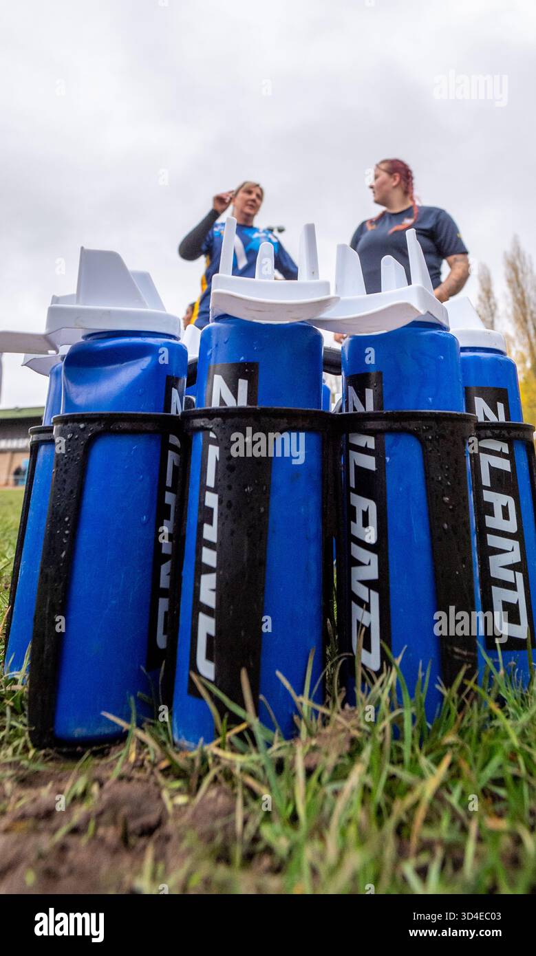 Weibliche Amateur-Rugby-Union mit blauen Ziland-Plastikflaschen. Stockfoto