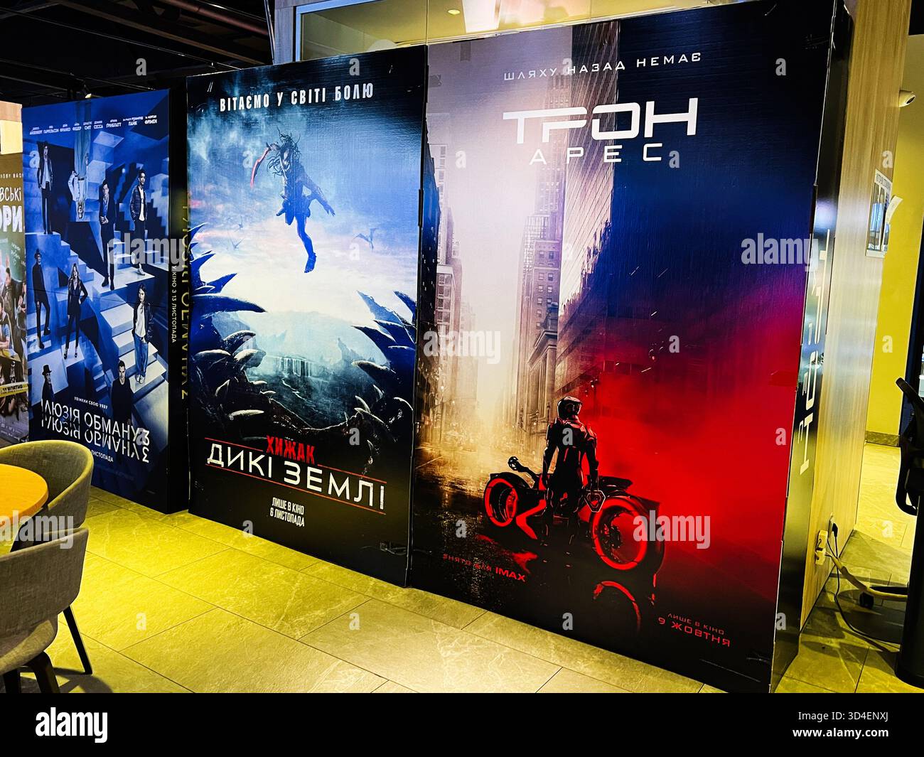 Kiew, Ukraine - 10. November 2025: Reihe von großen Tron, Ares und Predator, Badlands filmische Poster in einem öffentlichen Raum mit Science-Fiction und A Stockfoto