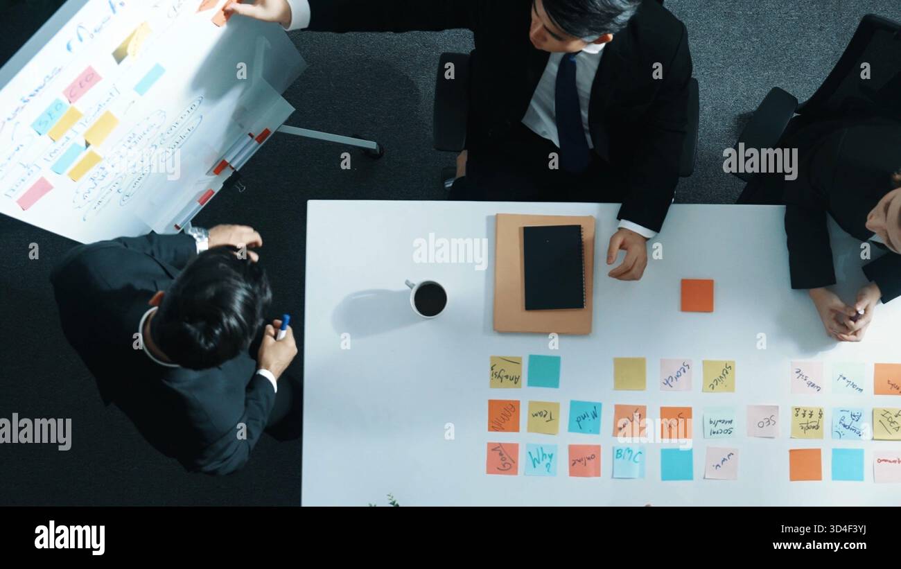Top-Down-Ansicht eines professionellen Geschäftsmannes Finden Sie eine Lösung, während Sie mithilfe von Haftnotizen eine Idee mit der Führungskraft zusammenstellen. Gruppe von Diversität Stockfoto