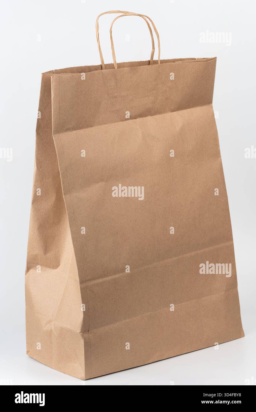 Die robuste braune Papiertüte steht aufrecht, ist bereit zum Einkaufen oder für Geschenke und zeigt ihr praktisches Design und ihre Griffe. Stockfoto