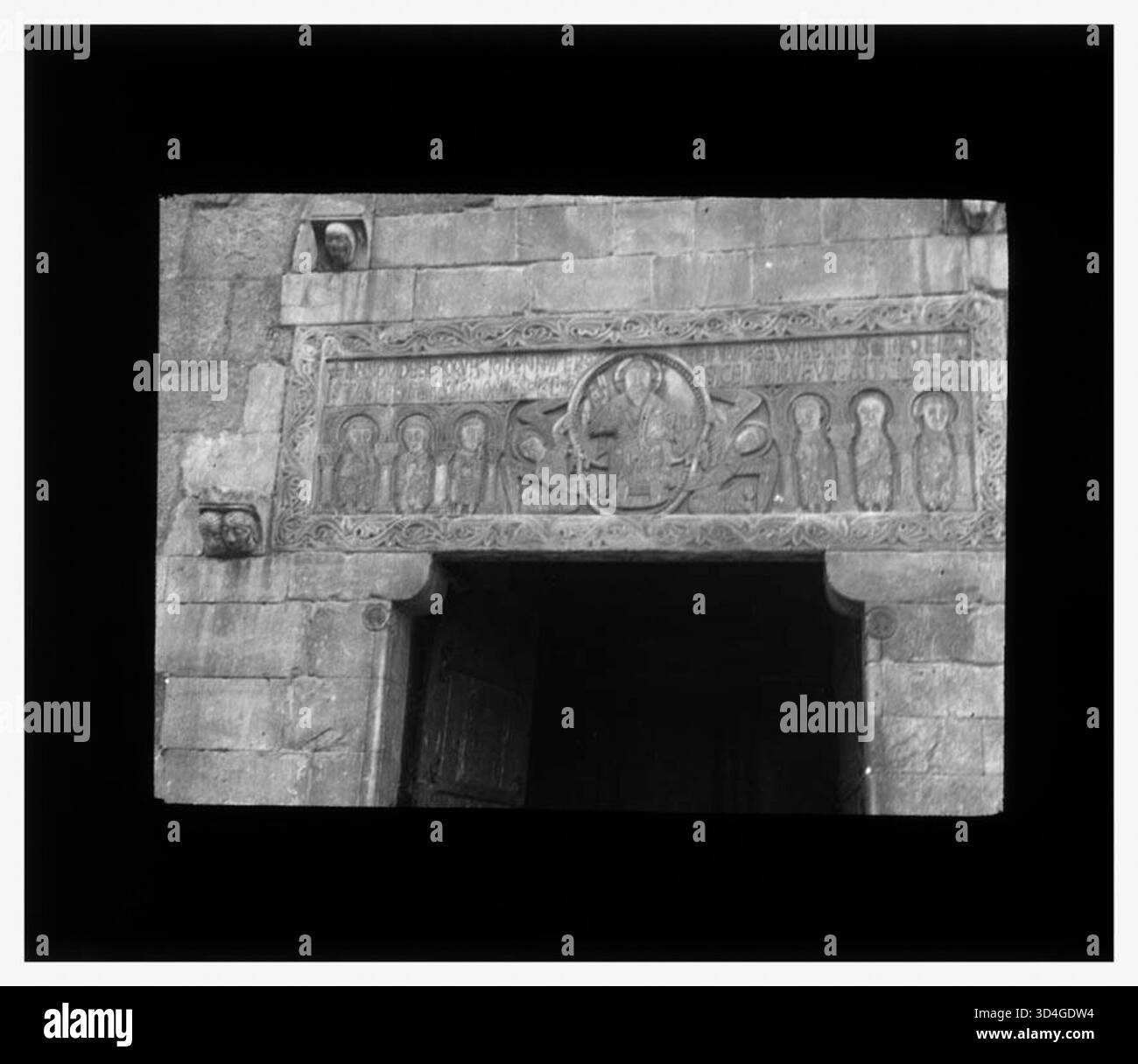 Relief mit religiösem Thema auf dem Türsturz des Portals bei der Abtei Sant Genís de Fontanes, fotografiert im September 1933 von Antoni Gallardo i. Garriga. Stockfoto