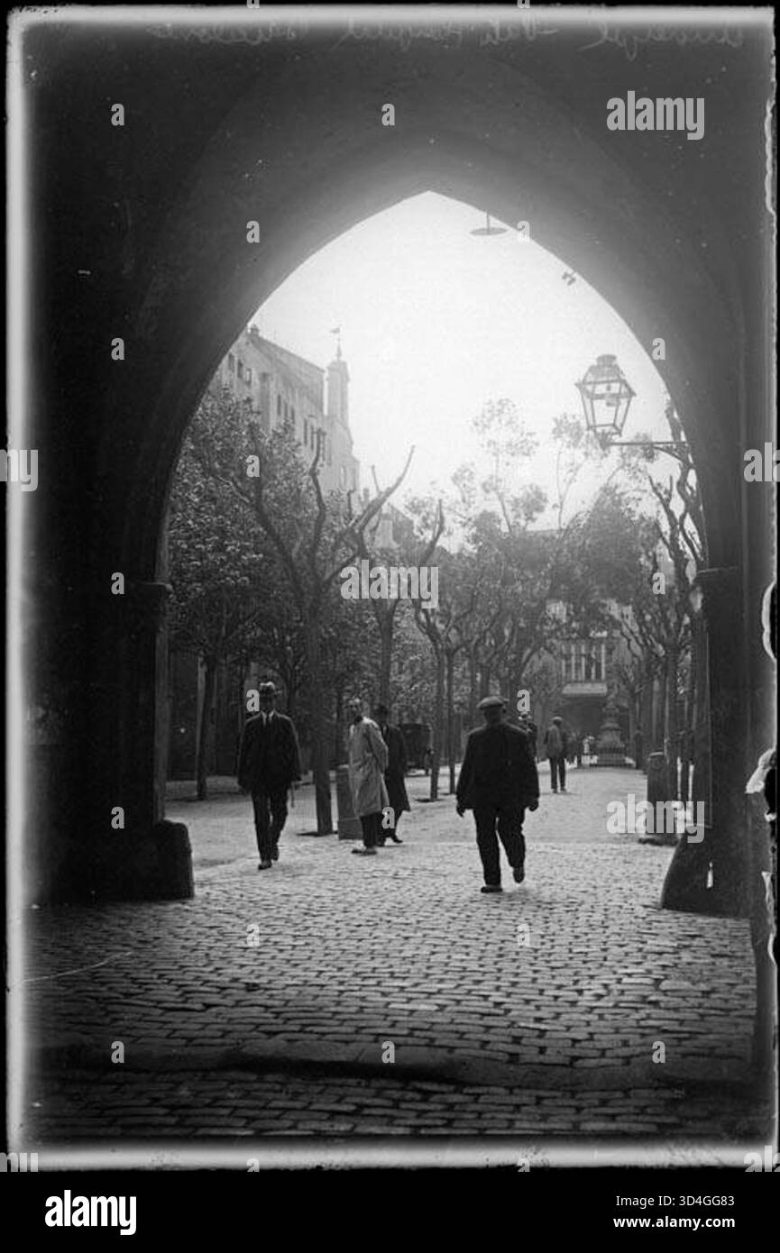 Dieses Bild, das von Josep Maria Armengol i Bas zwischen 1899 und 1915 aufgenommen wurde, zeigt das Portal und den Innenhof des Hospital de la Santa Creu, wobei Personen sichtbar sind. Stockfoto
