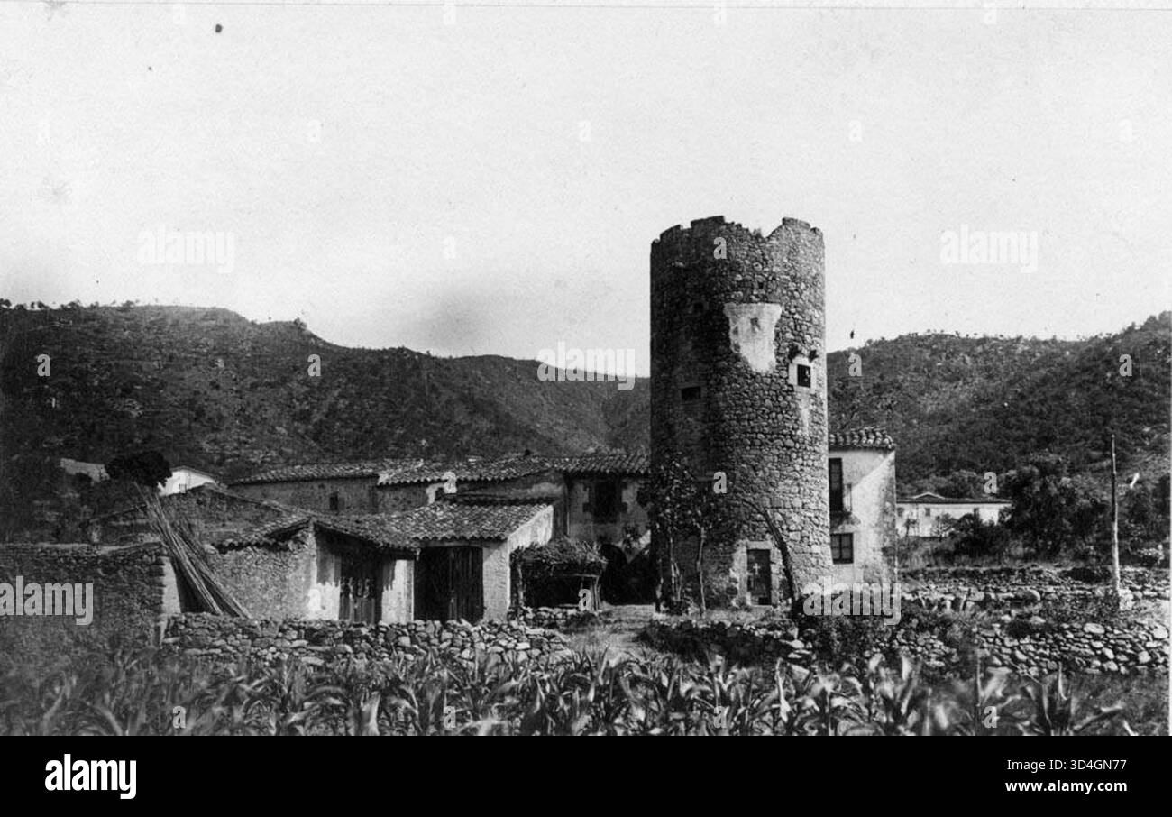 Dieses Foto zeigt eine Teilansicht von Cal Bacó mit seinem Turm, aufgenommen von Antoni Gallardo i Garriga im Jahr 1929. Es unterstreicht die charakteristischen architektonischen Merkmale des Gebäudes und der Umgebung. Stockfoto