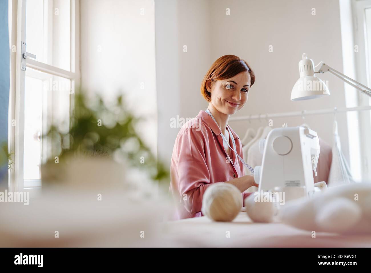 Eine Modedesignerin gründet ihr eigenes kleines Nähgeschäft. Stockfoto