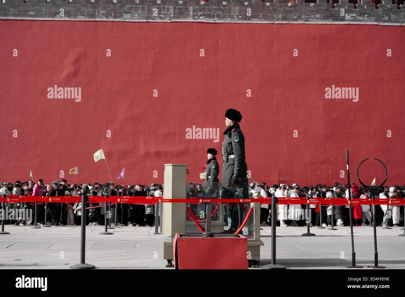 Wächter am Eingang der Verbotenen Stadt – Warteschlangen entlang der roten Wand; selektive Farbgebung Stockfoto