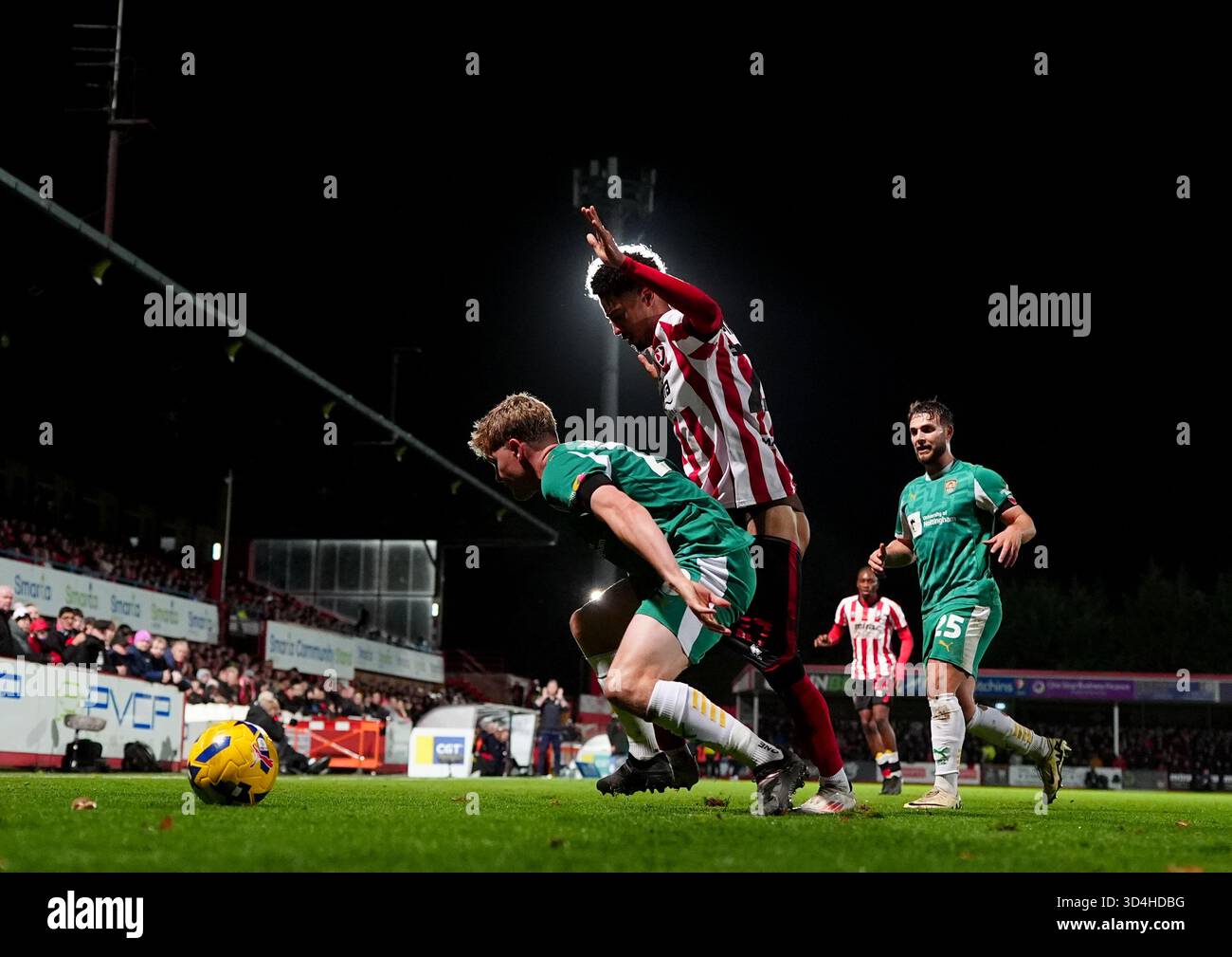 Scott Robertson von Notts County (links) und Jonathan Tomkinson von Cheltenham Town (Mitte) kämpfen um den Ball während des Spiels der Sky Bet League Two im EV Charger Points Stadium in Cheltenham 2025. Stockfoto