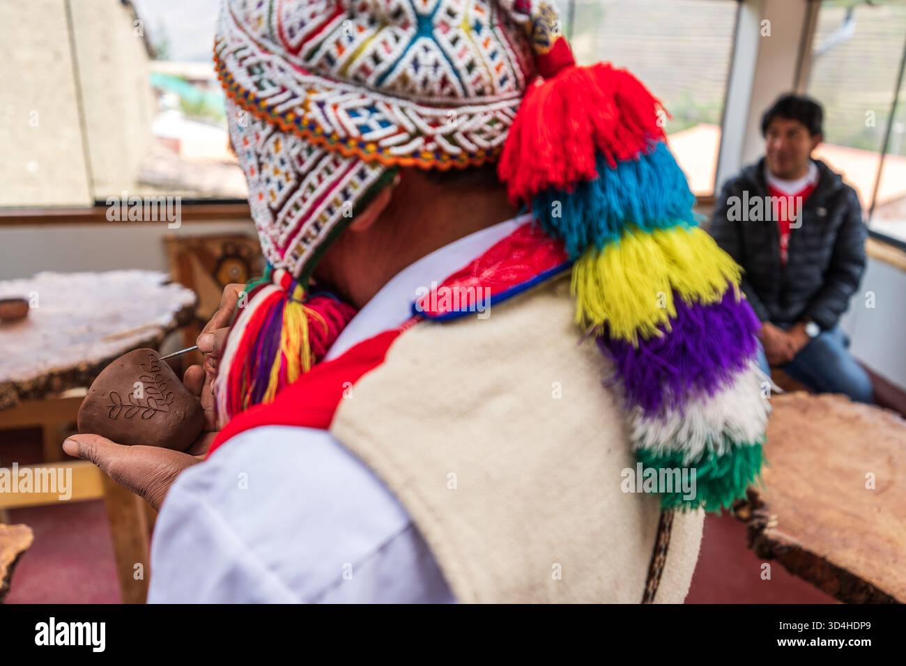 Nahaufnahme eines Quechua-Handwerkers, der während eines Töpferkurses in der Keramikwerkstatt einen Tonbecher formt. Pisac, Region Cusco, Peru, 29.05.2025. Stockfoto