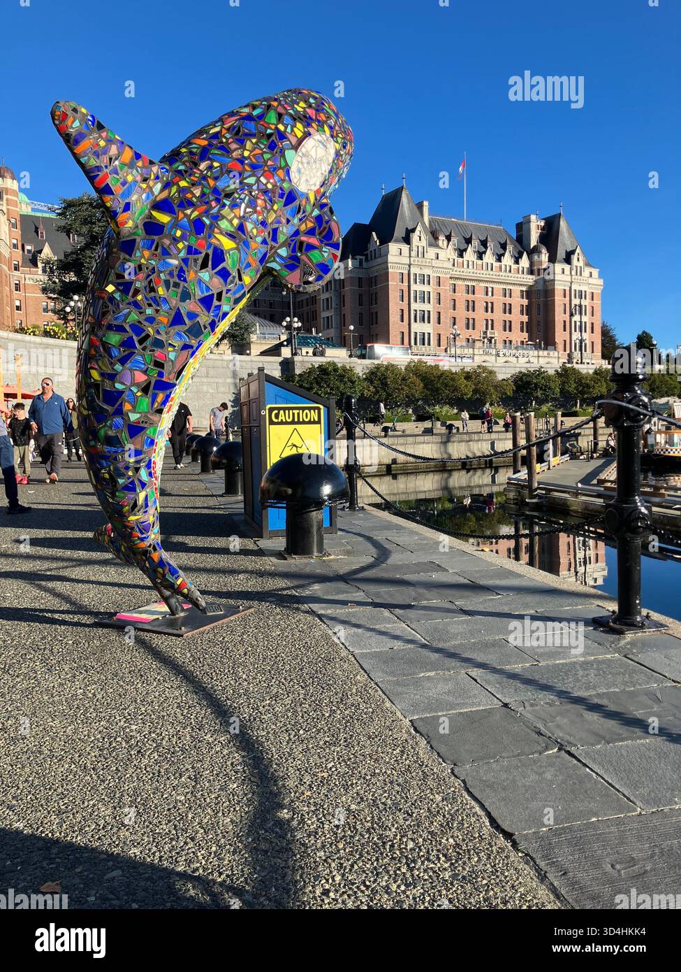 „Millenium Orca“-Mosaikskulptur im Inner Harbour mit Empress Hotel im Hintergrund. Victoria, Vancouver Island, British Columbia, Kanada - Smartphone-aufgenommenes Stockfoto