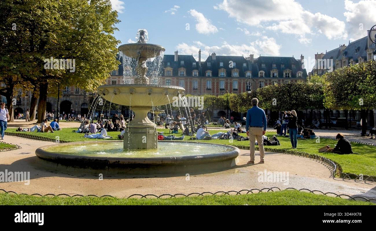 Menschen, die die Sonne genießen, am Place des Vosges, Marais, Paris, Frankreich Stockfoto