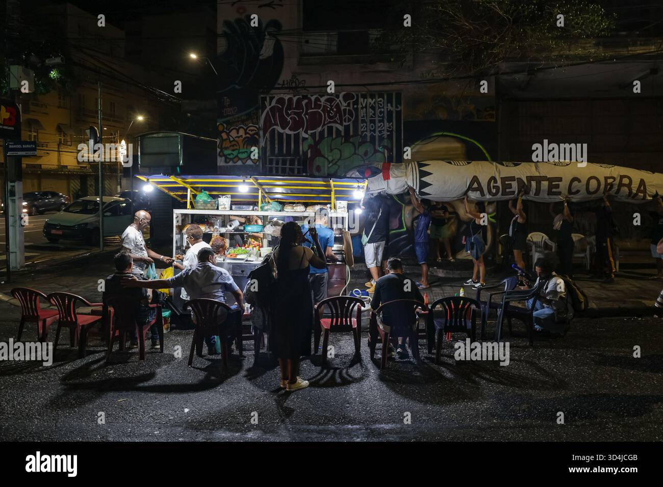Belem, Brasilien. November 2025. Aktivisten bereiten sich auf den marsch mit einer Schlangenpuppe (r) neben einer Snackbar vor. Die Aktivisten trugen die Schlangenpuppe mit der Aufschrift „A gente cobra“ („Wir fordern Aktion“) während einer Demonstration zur Verteidigung der Amazonasregion am Eröffnungstag der COP30. Die Demonstration auf der Avenida Presidente Vargas enthielt Projektionen und Symbole, in denen Klimagerechtigkeit gefordert und die Verantwortlichen für Umweltschäden zur Rechenschaft gezogen werden sollten. Quelle: Allison Sales/dpa/Alamy Live News Stockfoto