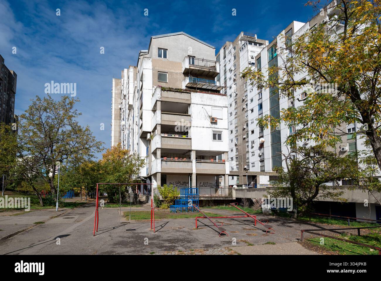 Brutalistische Wohngebäude aus der jugoslawischen Ära mit einem Gemeinschaftsspielplatz im Blok 62 in Neubelgrad. Oktober 2025. Stockfoto