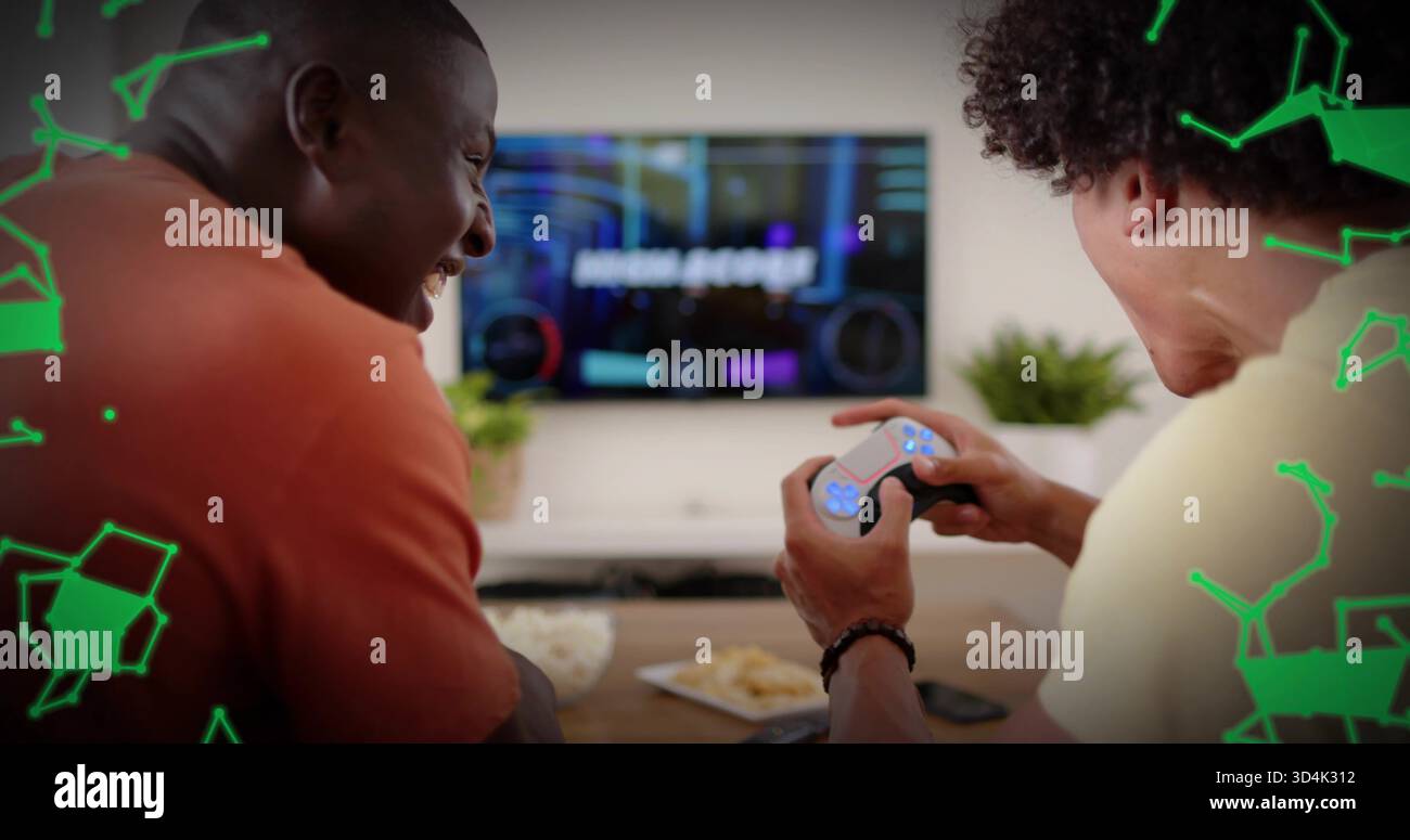 Sie spielen zwei Männer in lässiger Kleidung auf der Couch, halten den Wireless-Controller und lachen über den Wandfernseher Stockfoto