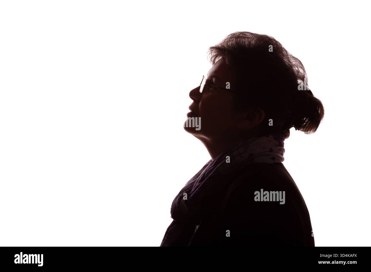 Dunkle Silhouette einer älteren Frau, einer Rentnerin mit lockigem Haar in der Brille - isolieren, weißer Hintergrund Stockfoto