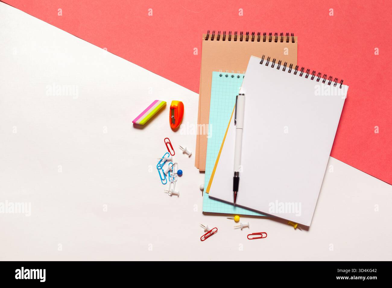 Bunte Schreibwaren auf einem Schreibtisch mit Notizbüchern und Bürobedarf Stockfoto