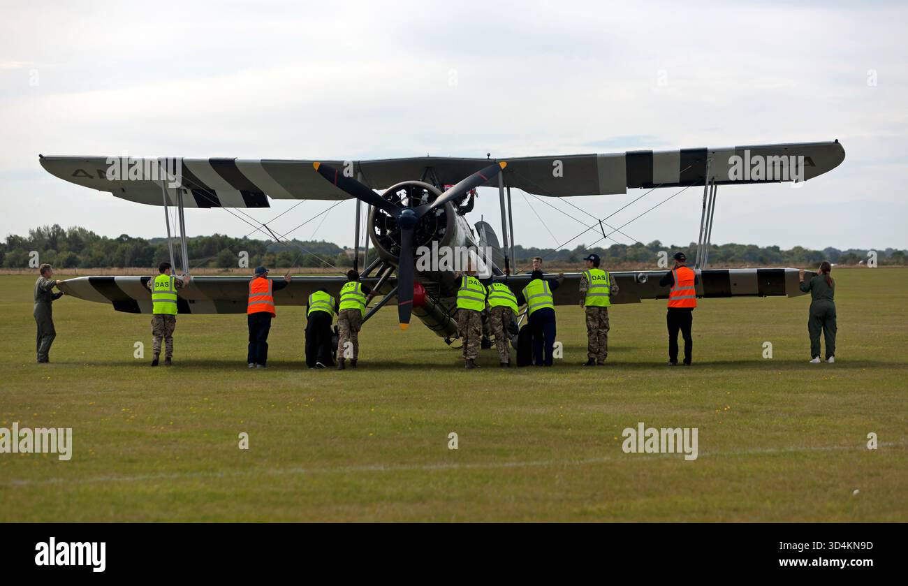 Mitglieder der Duxford Aviation Society helfen, den Fairy Swordfish Mk1 zurückzudrängen, bevor er während der Battle of Britain Air Show gezeigt wird Stockfoto