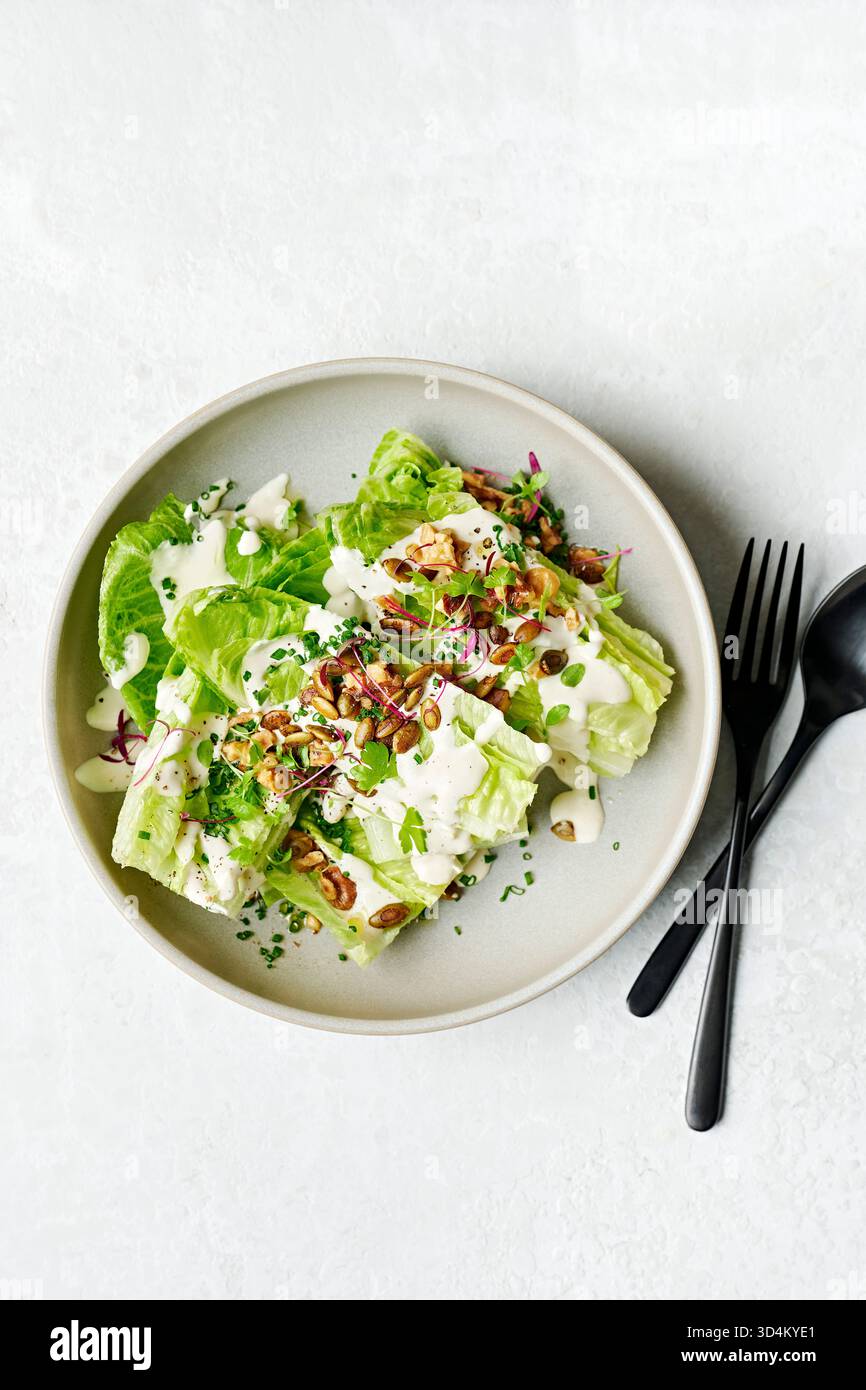 Beilagensalat mit Baby Cos Wedges, Parmesan & Schnittlauch Dressing, geröstete Walnüsse, Tamari pepitas Stockfoto