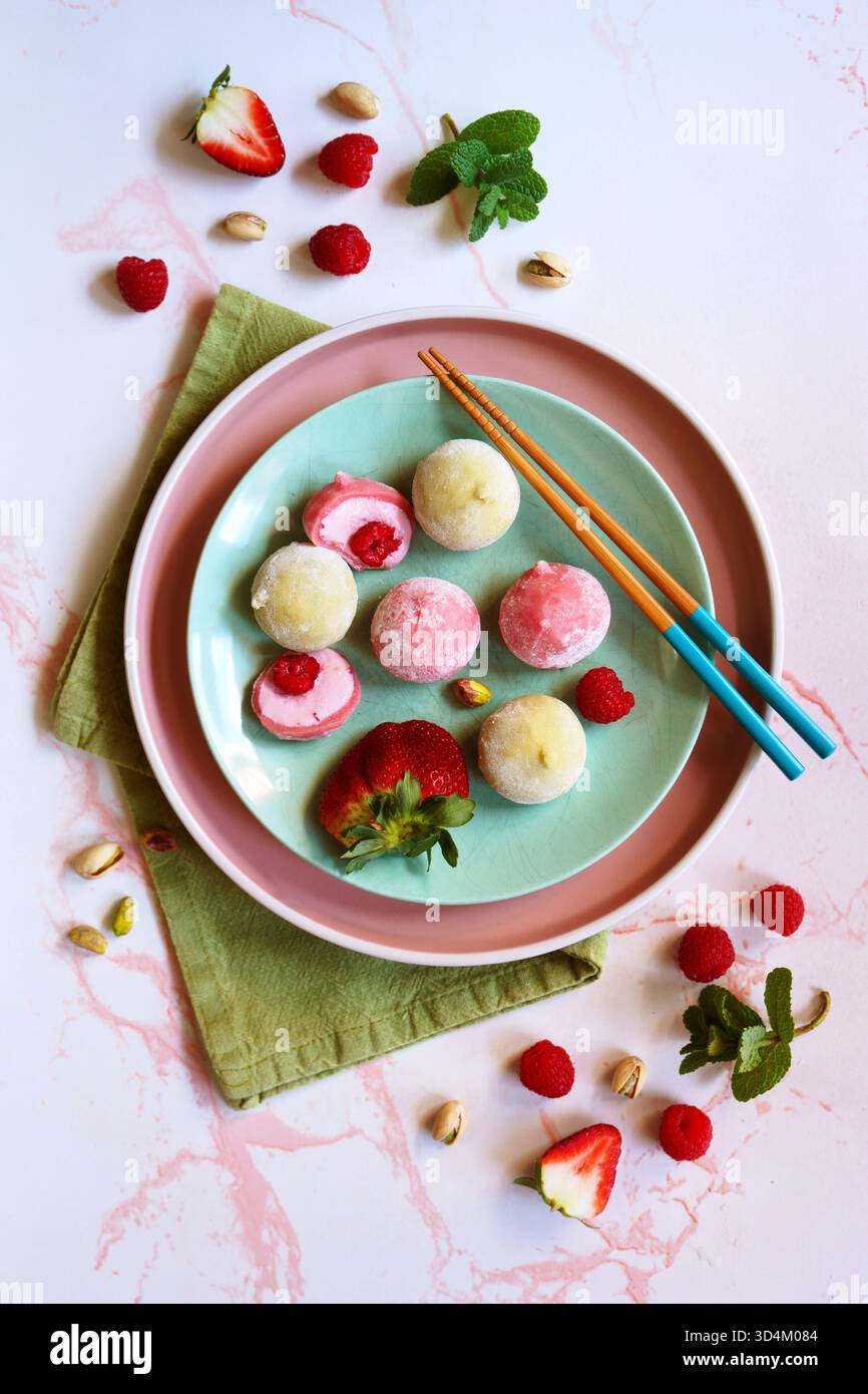 Traditionelles japanisches Mochi-Dessert. Beeren- und Pistazienaromen. Rosa und grüne Ästhetik. Stockfoto