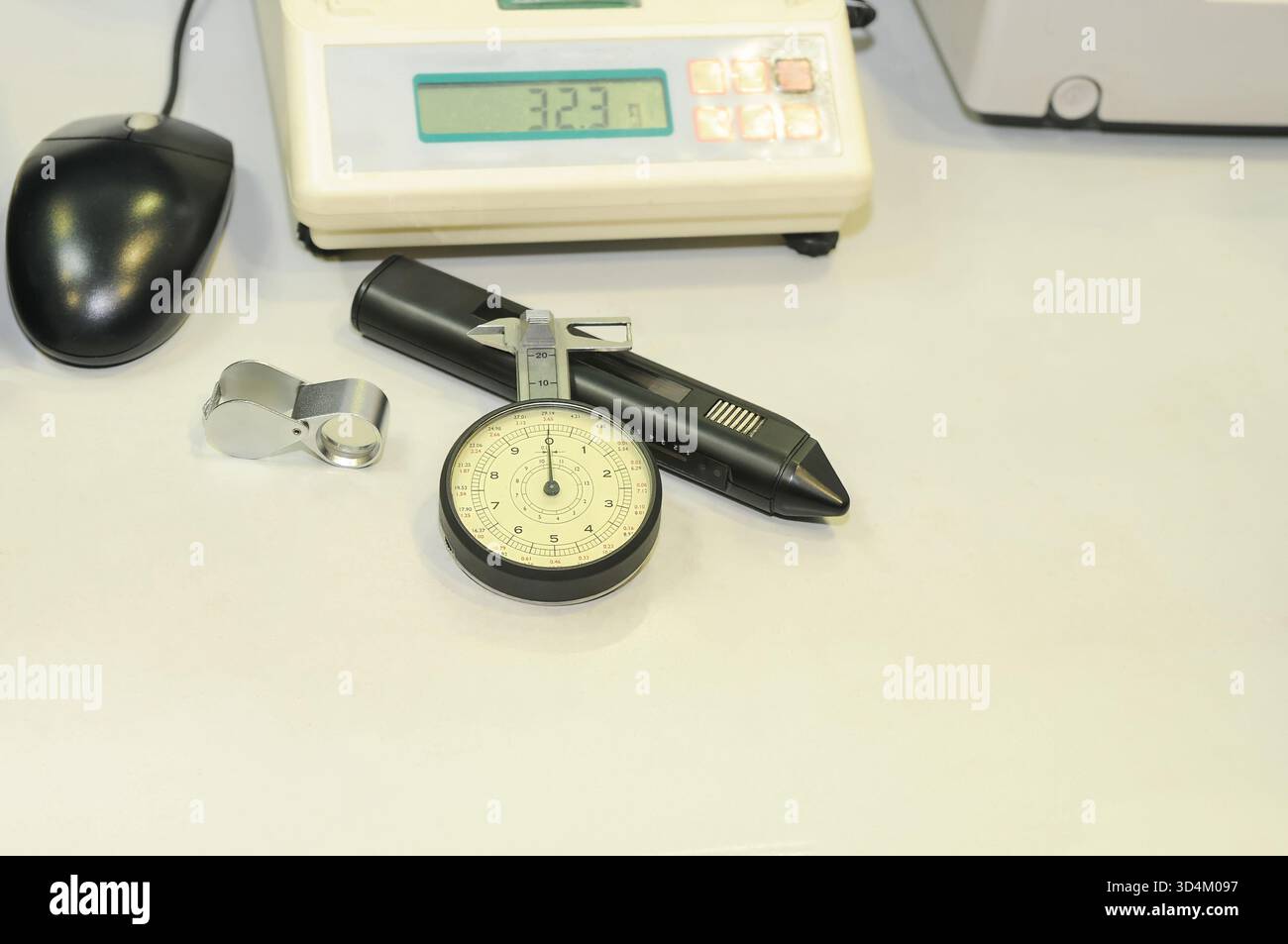 Nahaufnahme eines Edelsteinschiebers neben anderen Schmuckwerkzeugen auf einem Tisch. Stockfoto